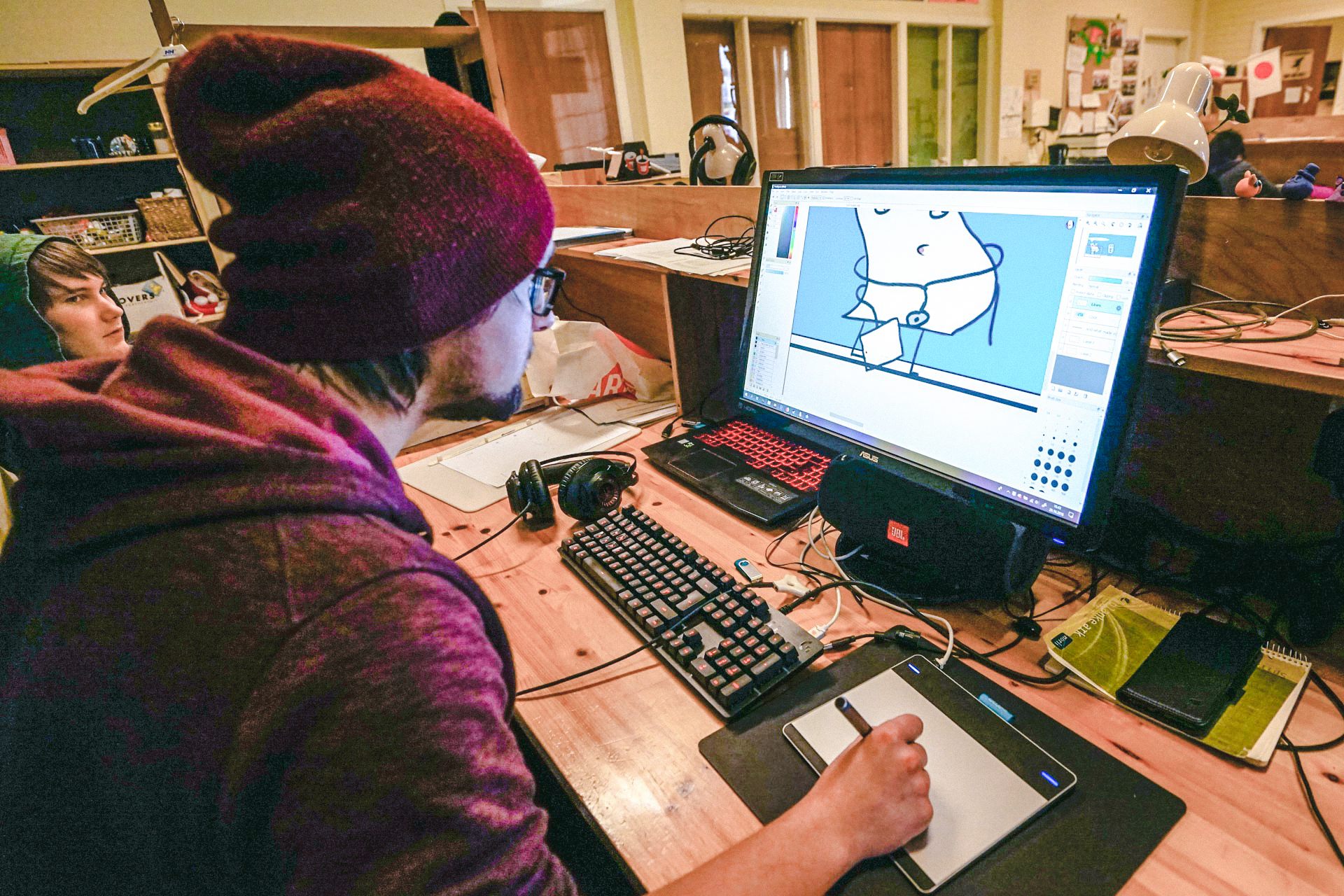 Ein student sit på datamaskin og teiknar illustrasjon for teikneserie valfag.