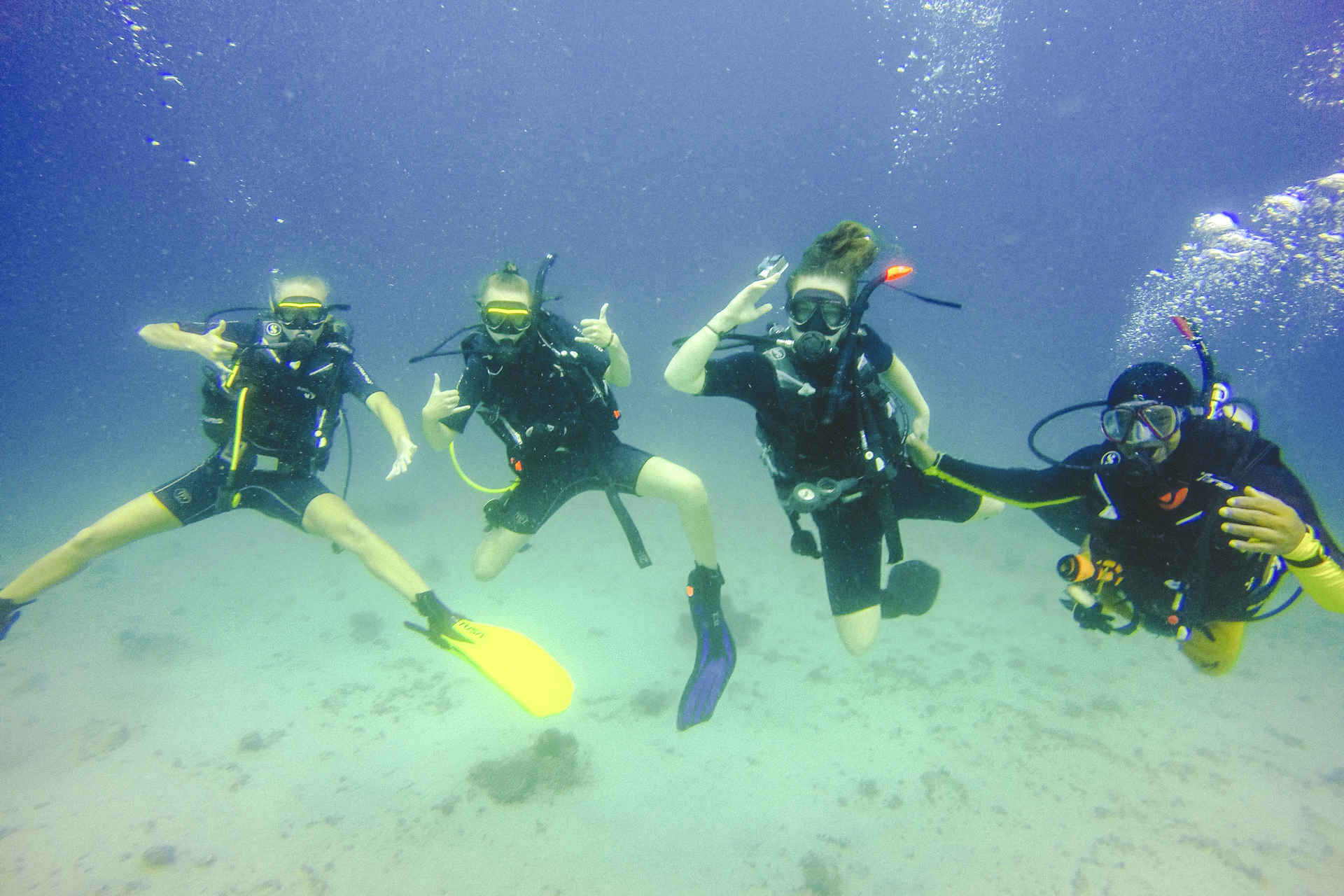 Undervannsbilde av fire elevar på Friluftsliv X linja på dykketur